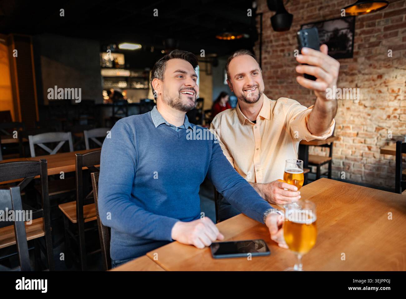 Two men taking selfie drinking beer in a bar Stock Photo