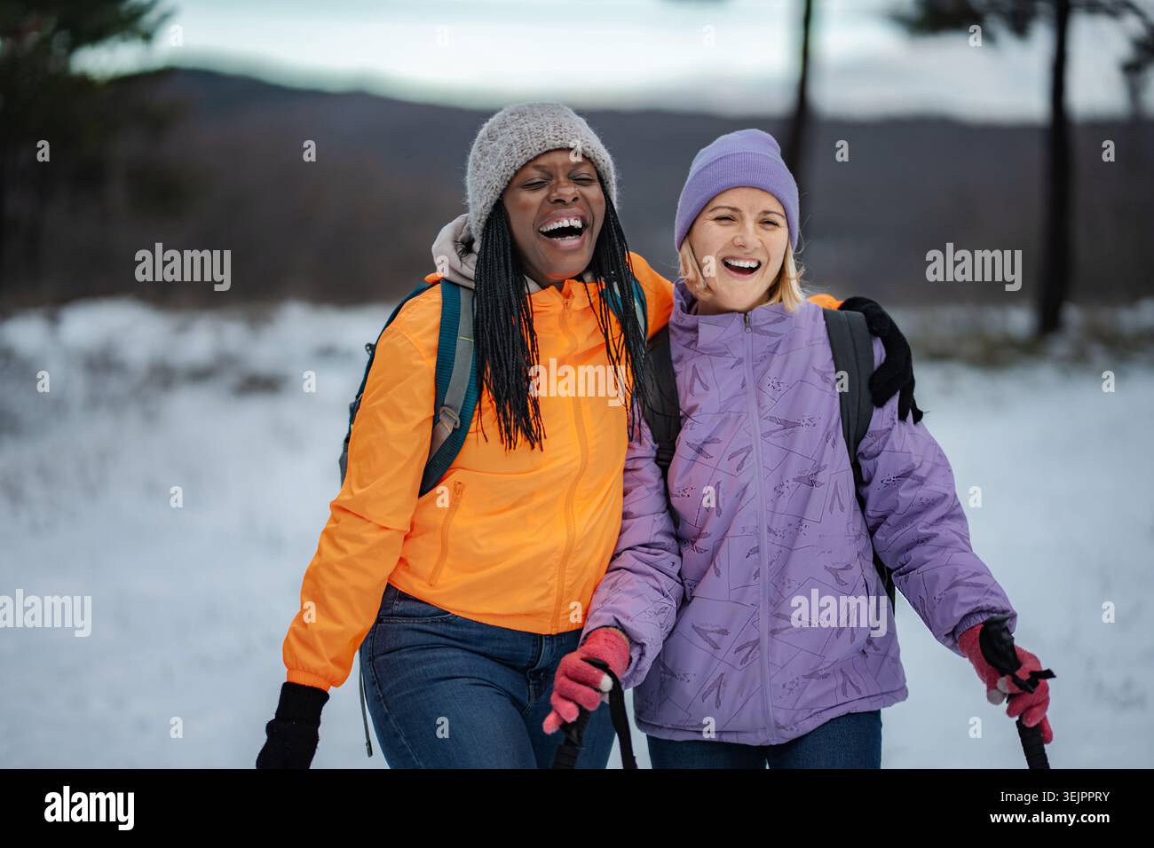 Happy diverse women friends hiking in winter snow Stock Photo