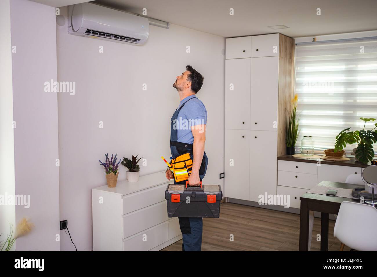 Technician looking and checking air conditioning unit with toolbox Stock Photo