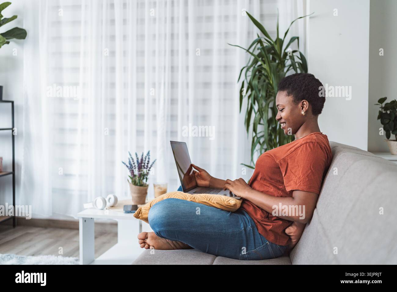 Young Woman Working From Home on Laptop Stock Photo
