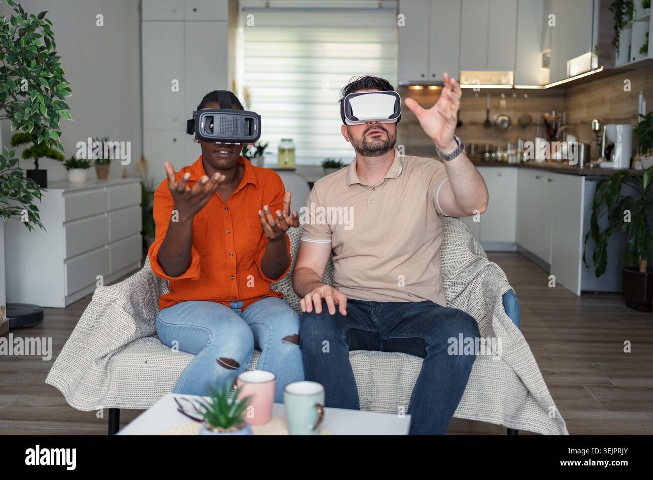 Multi-ethnic couple using vr headset in living room Stock Photo