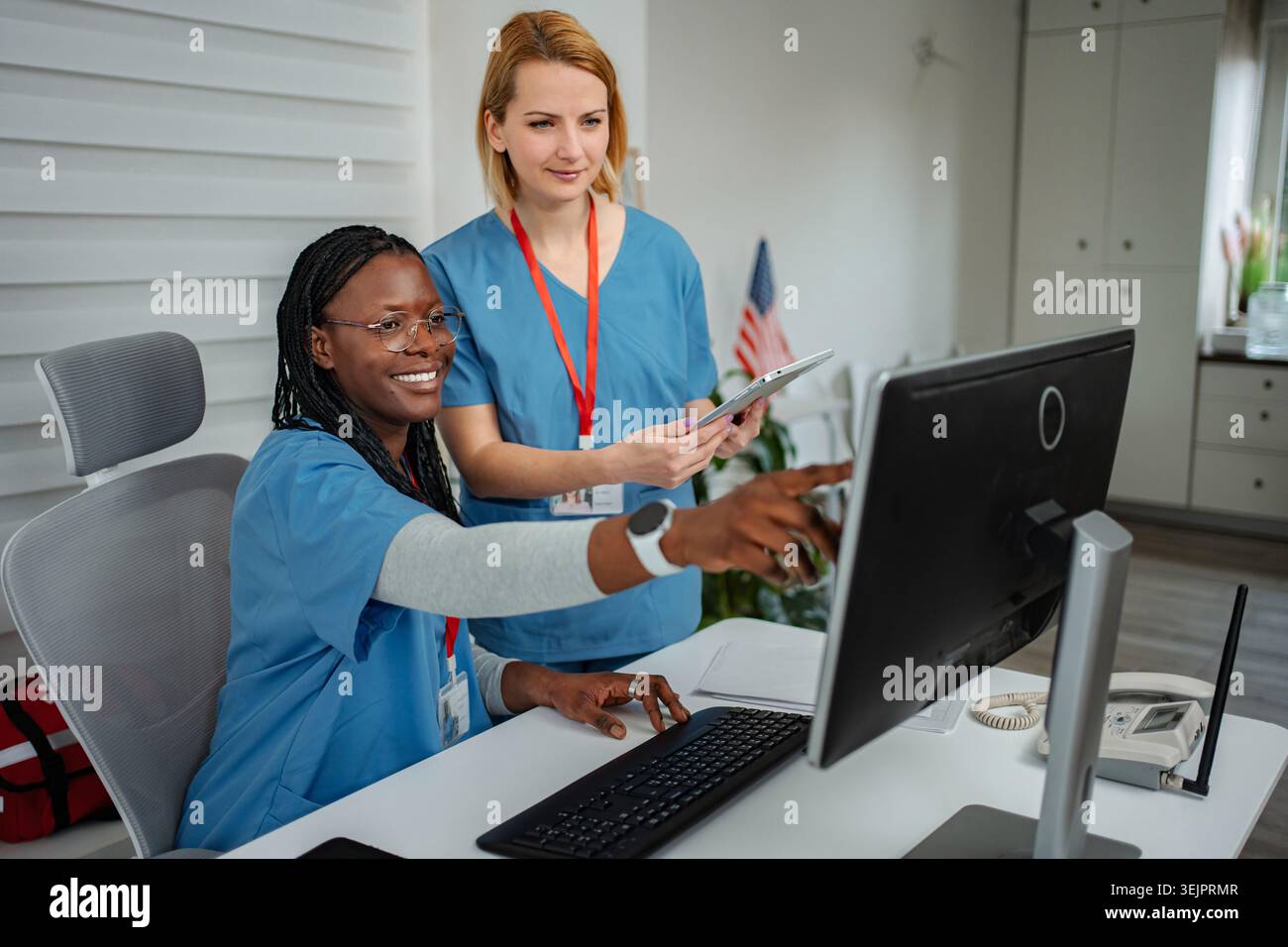 Healthcare professionals collaborating on computer using digital tablet Stock Photo