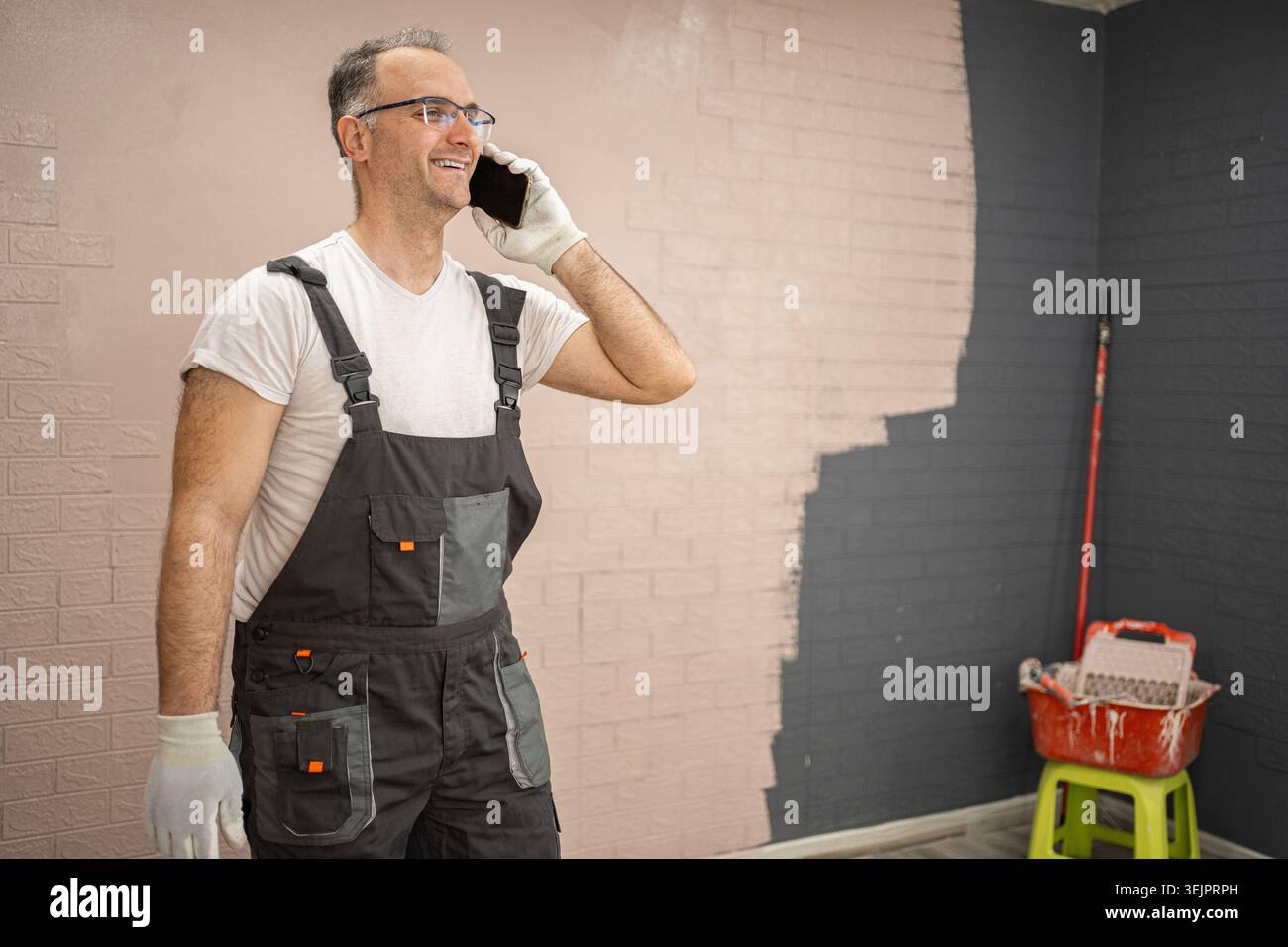 Man in Overalls Talking on Cell Phone Stock Photo