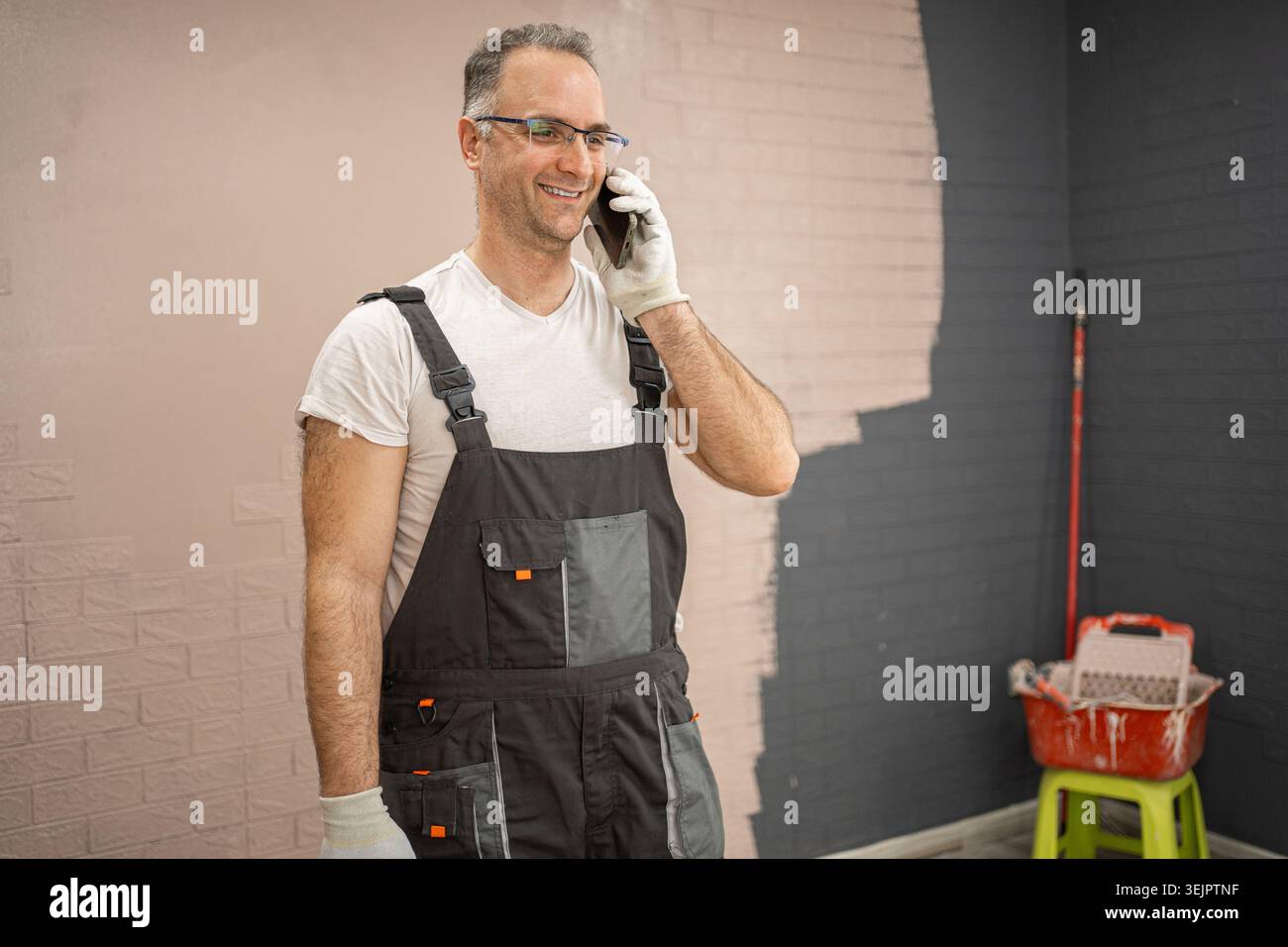 Man in Overalls Talking on Cell Phone Stock Photo