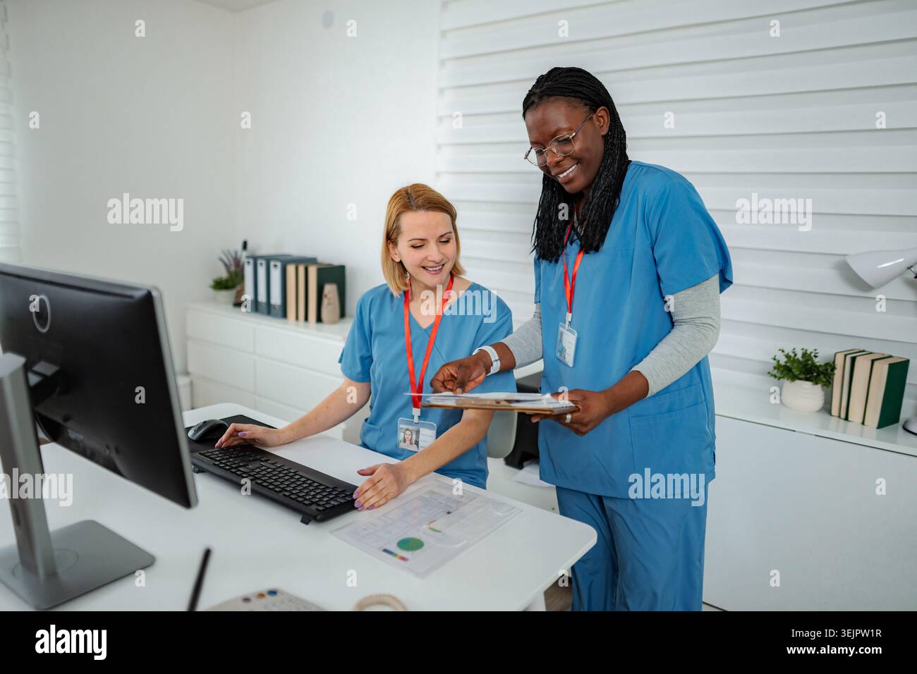 Female nurses collaborating on computer during busy shift Stock Photo