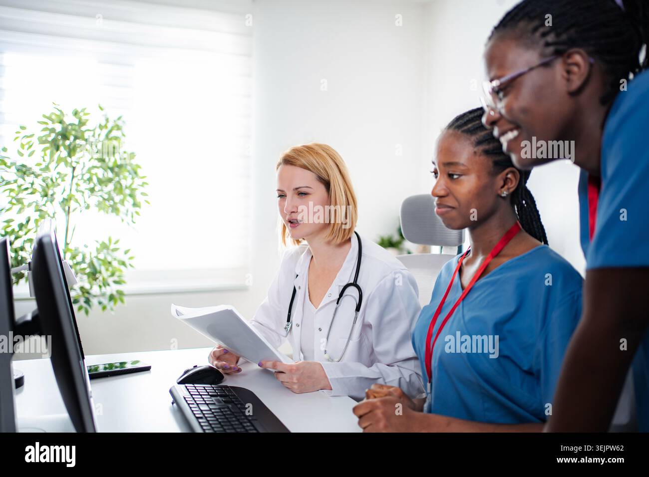 Medical team collaborating on computer in modern office Stock Photo