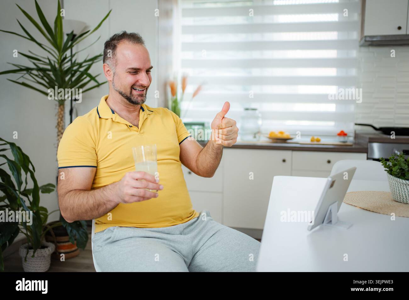 Man giving thumbs up during video call at home Stock Photo