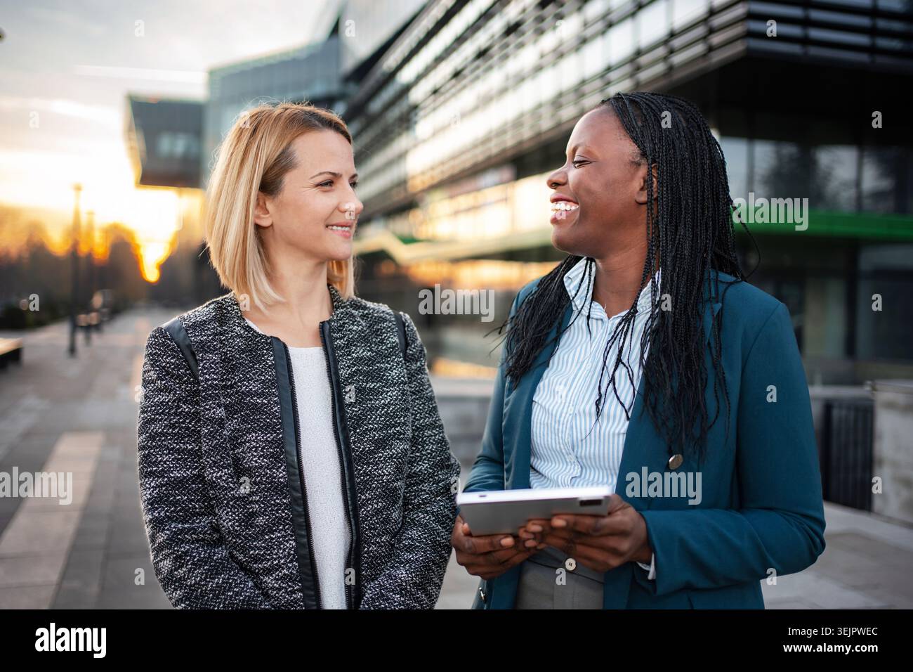 Diverse businesswomen colleagues discussing work using digital tablet Stock Photo