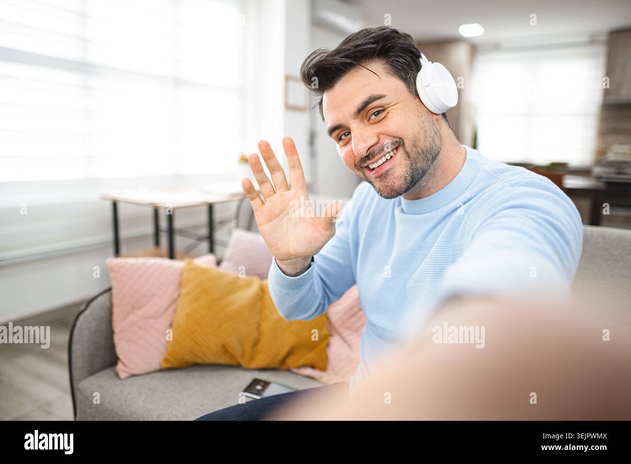 Selfie of brown-haired smiling man with white headphones Stock Photo