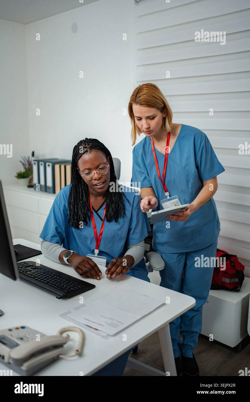 Nurses discussing data while working in a hospital office Stock Photo