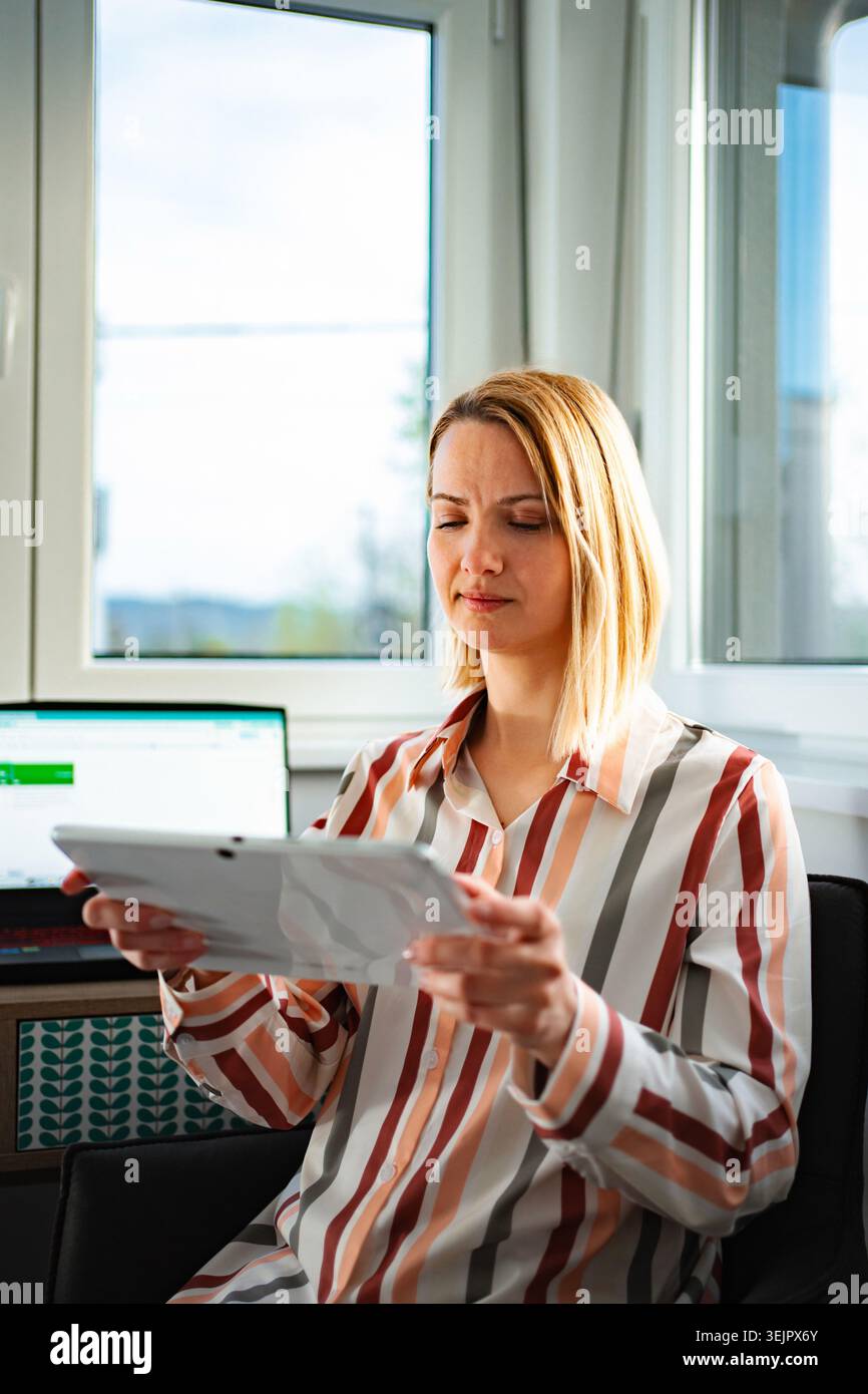 Woman closing eyes feeling tired from digital tablet work Stock Photo