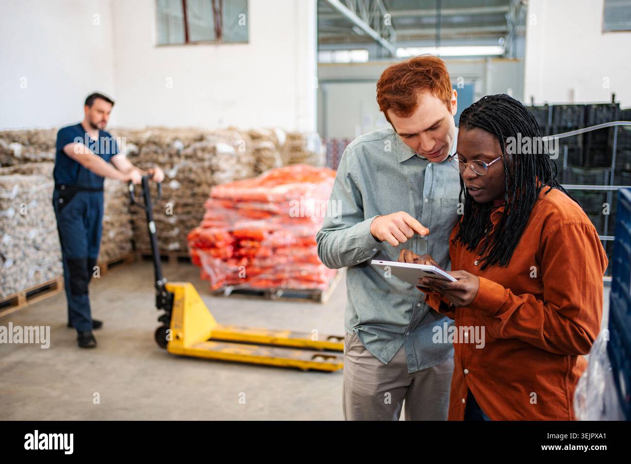 Diverse warehouse colleagues using digital tablet for inventory management Stock Photo