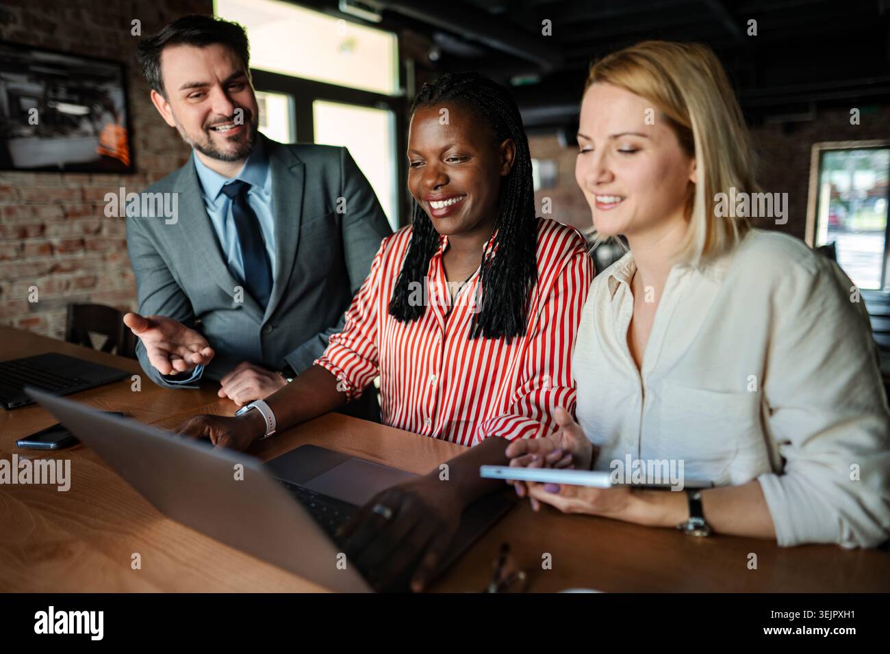 Diverse startup team collaborating on business strategy using laptop Stock Photo