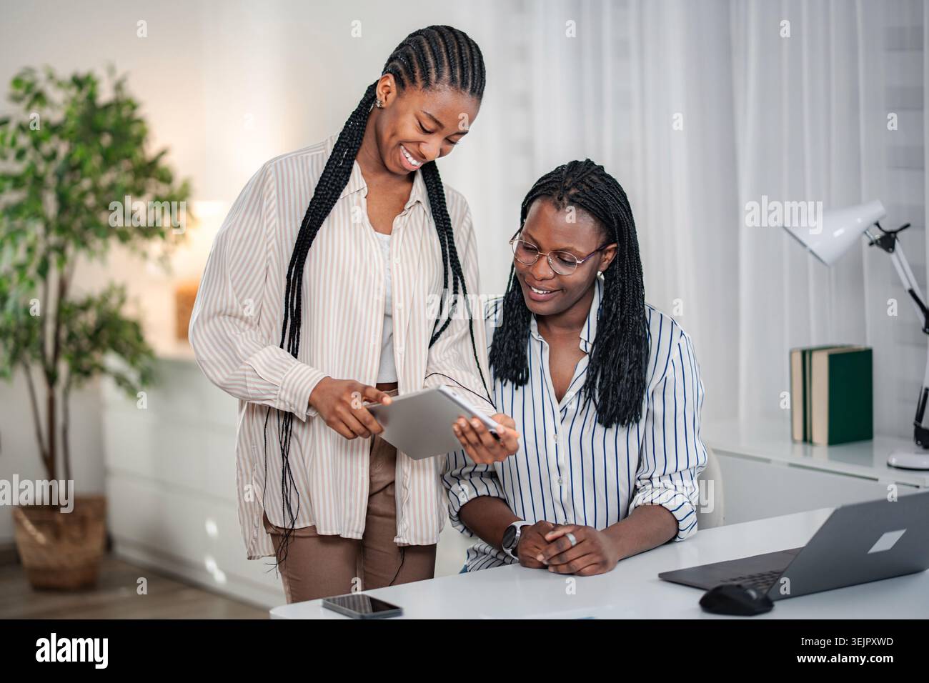 Black women collaborating using tablet in office Stock Photo
