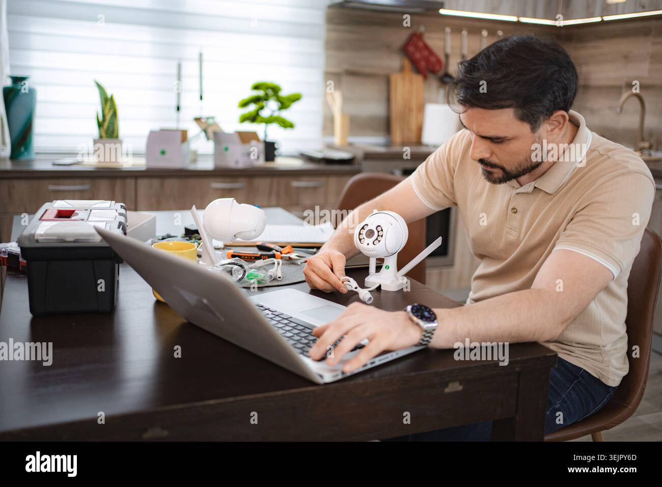 Technician installing surveillance camera using laptop at home Stock Photo