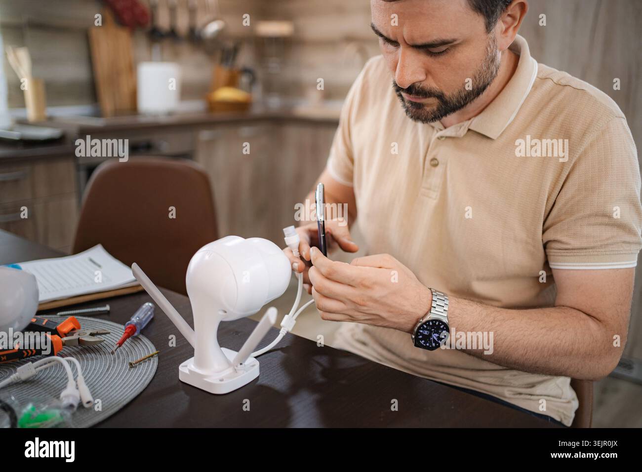 Man installing a new wireless surveillance camera at home Stock Photo