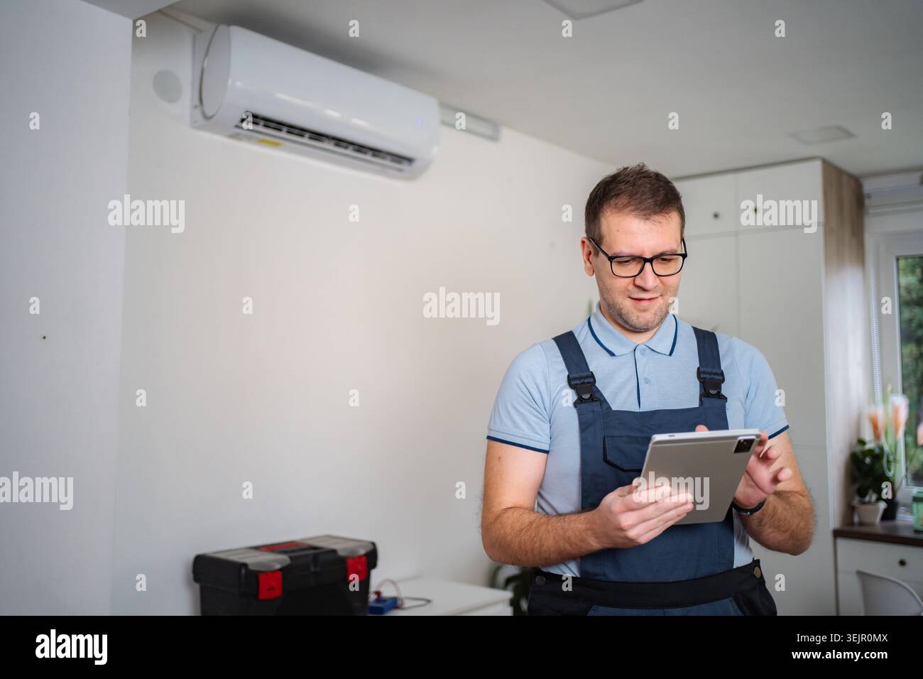 Technician checking air conditioner with digital tablet Stock Photo
