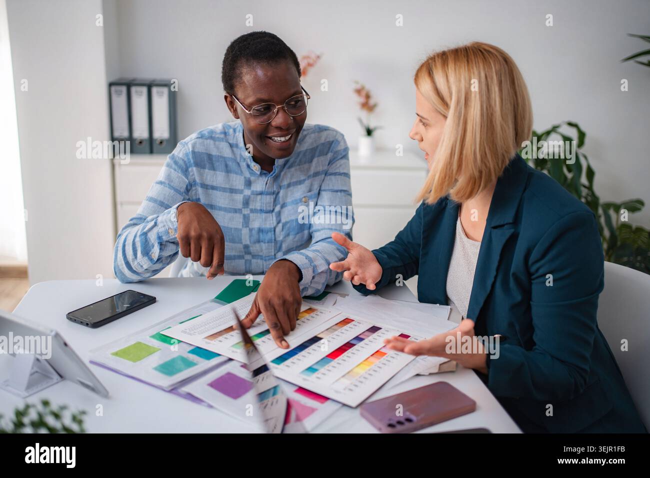 Diverse designers collaborating on color palette for creative project Stock Photo