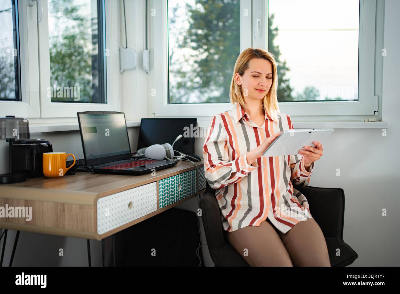 Woman freelancer working from home using digital tablet technology Stock Photo