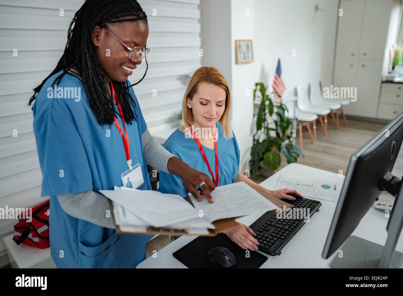 Nurses collaborating in modern clinic office working on computer Stock Photo