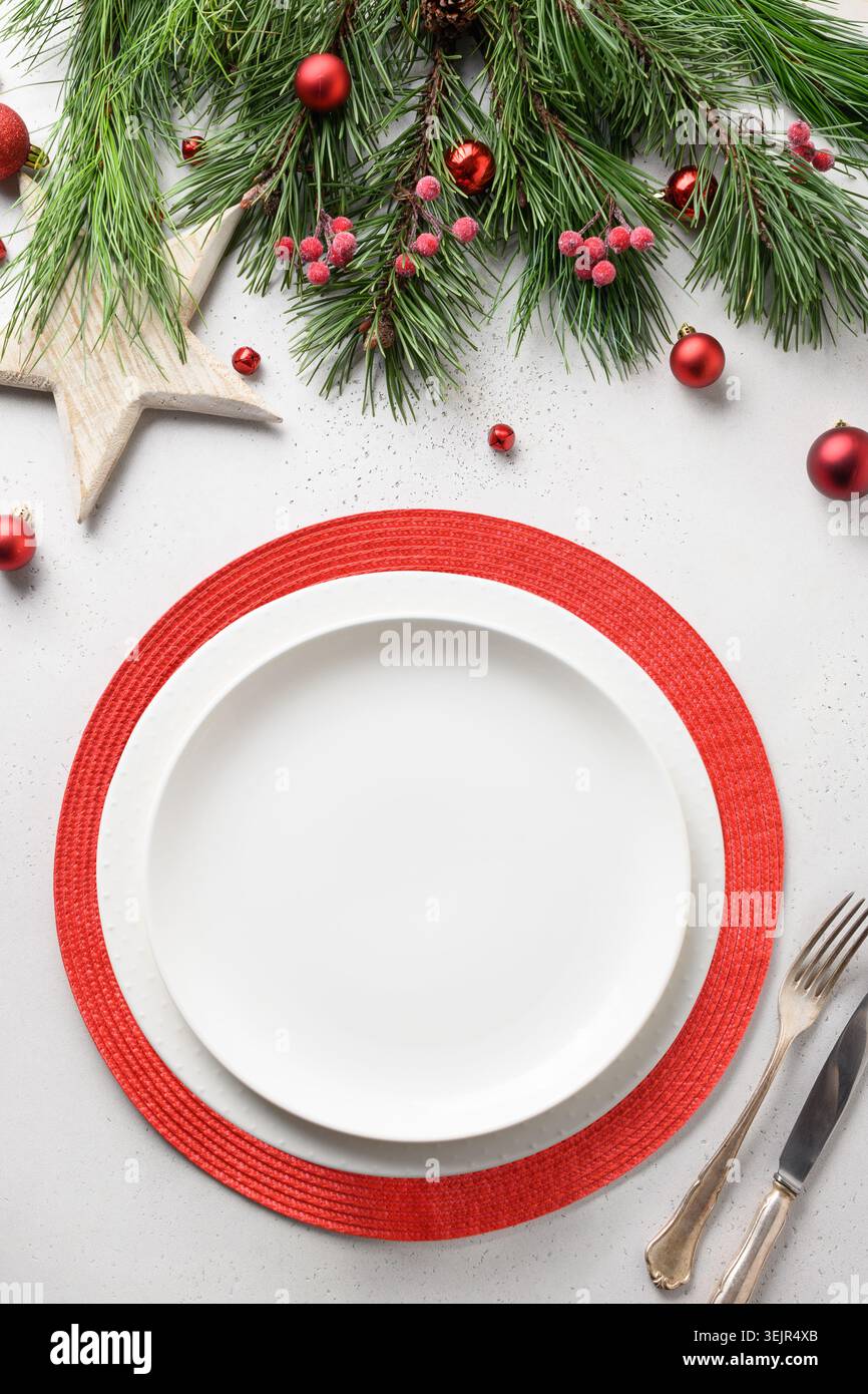 Christmas festive table setting with white and red holiday elegant decorations on white. Stock Photo