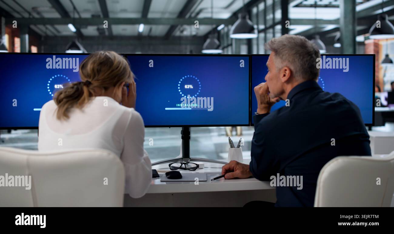Two IT Specialists Working Together On Updating Slow Computer Systems. Stock Photo