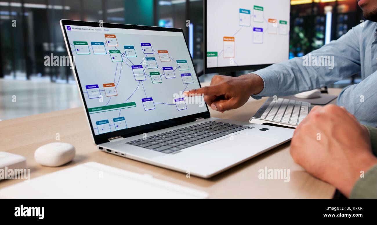Two Software Engineers Planning Automated Workflow System Using Laptop Together. Stock Photo