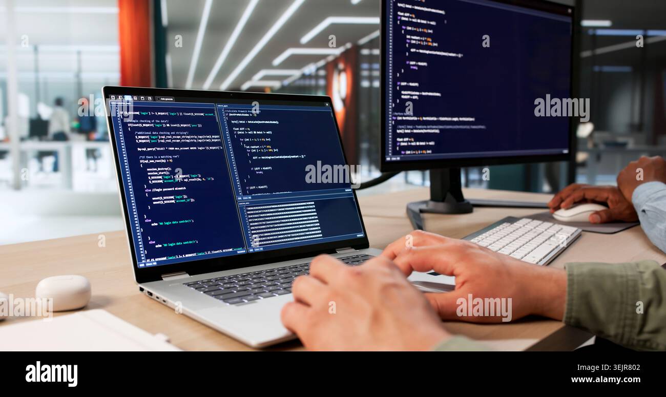 Two Software Engineers Work Together Coding Secure Data Systems At Desk. Stock Photo