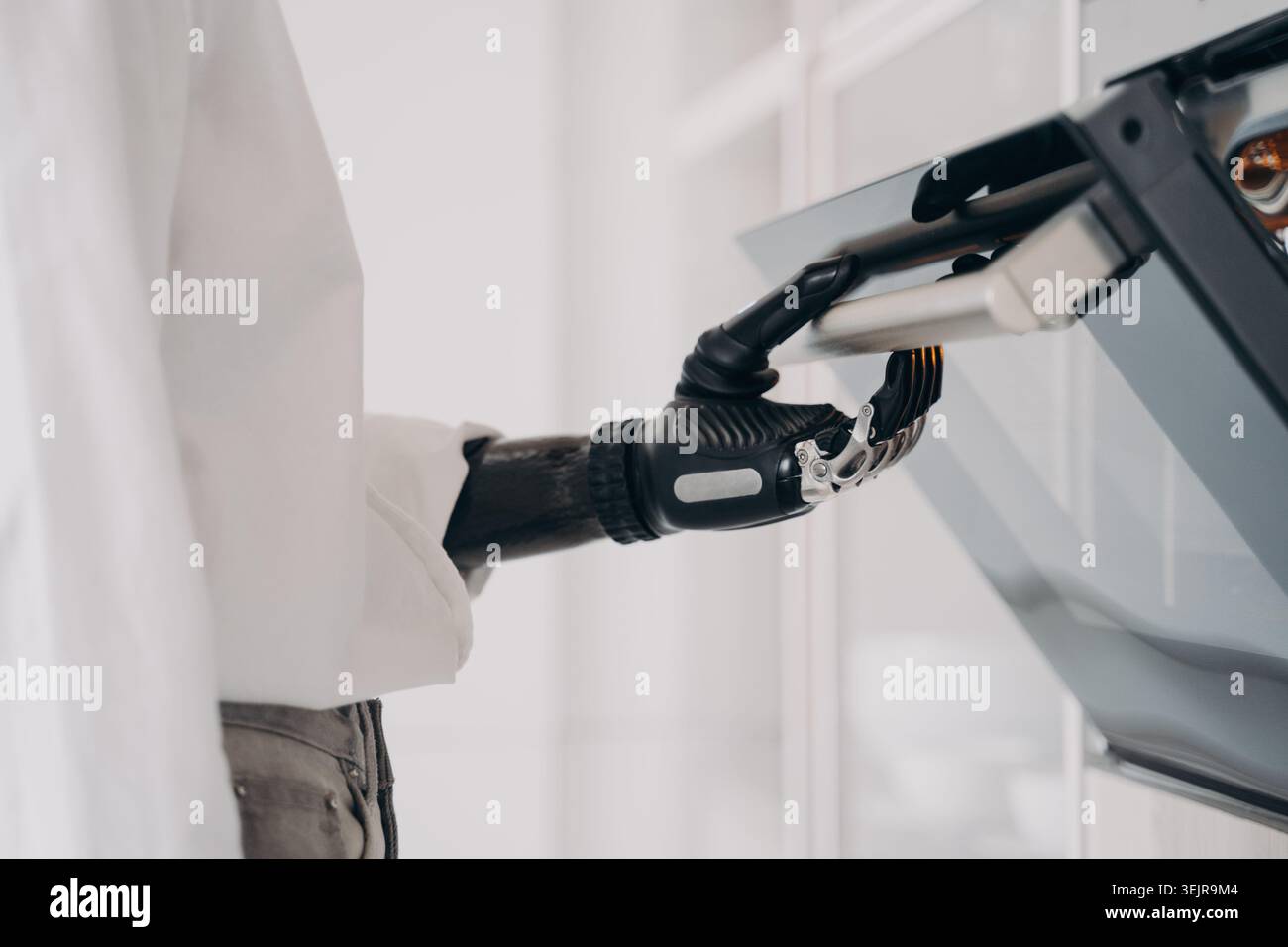 Person with prosthetic hand using touchscreen device at home close up Stock Photo