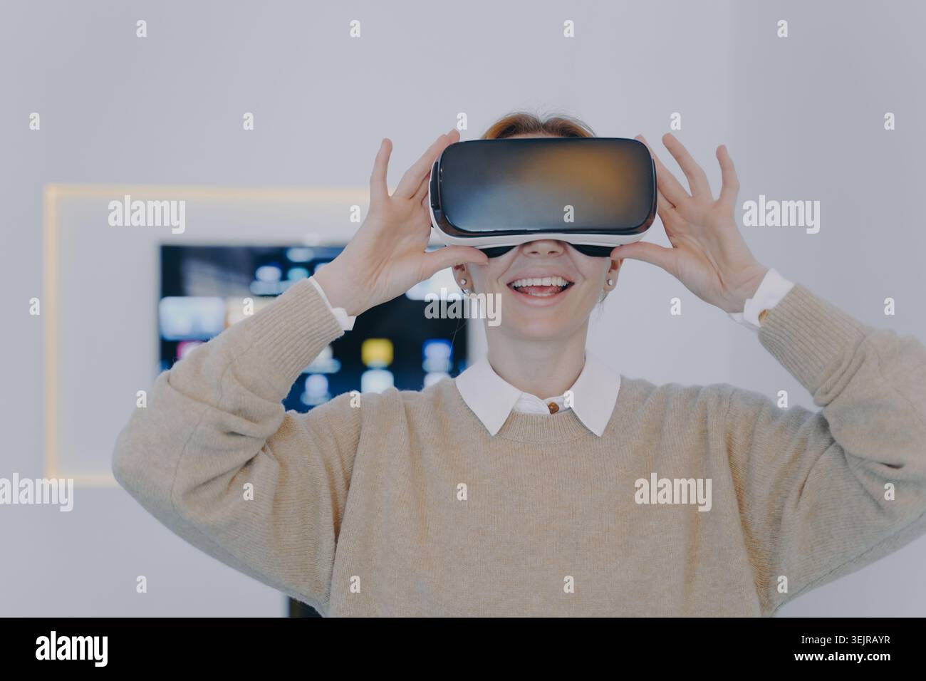 Woman using virtual reality headset at home during immersive VR experience Stock Photo