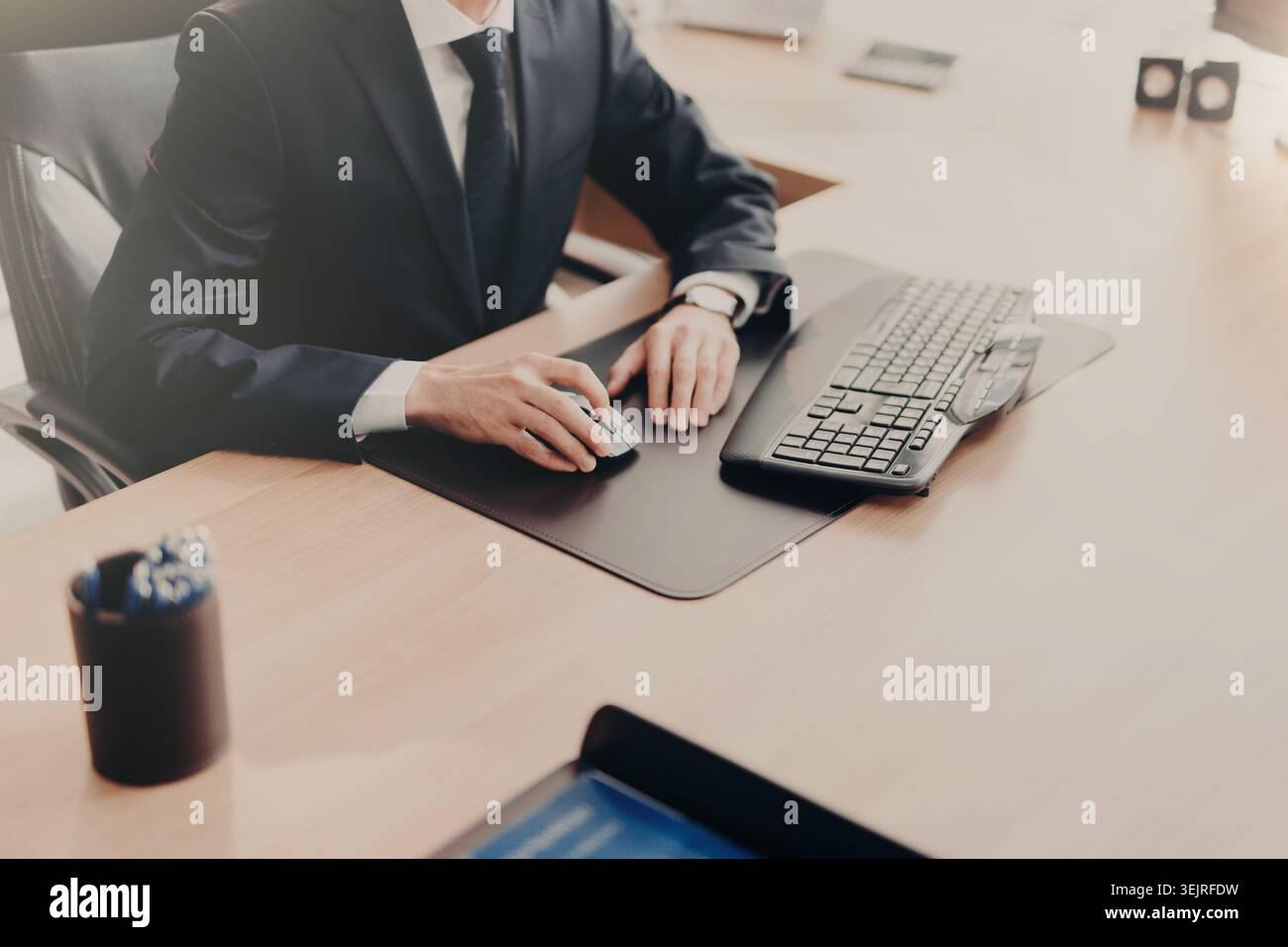 Businessman using computer mouse and keyboard at office desk Stock Photo