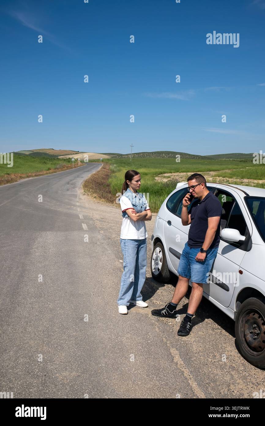 Couple experiencing car breakdown on rural road Stock Photo