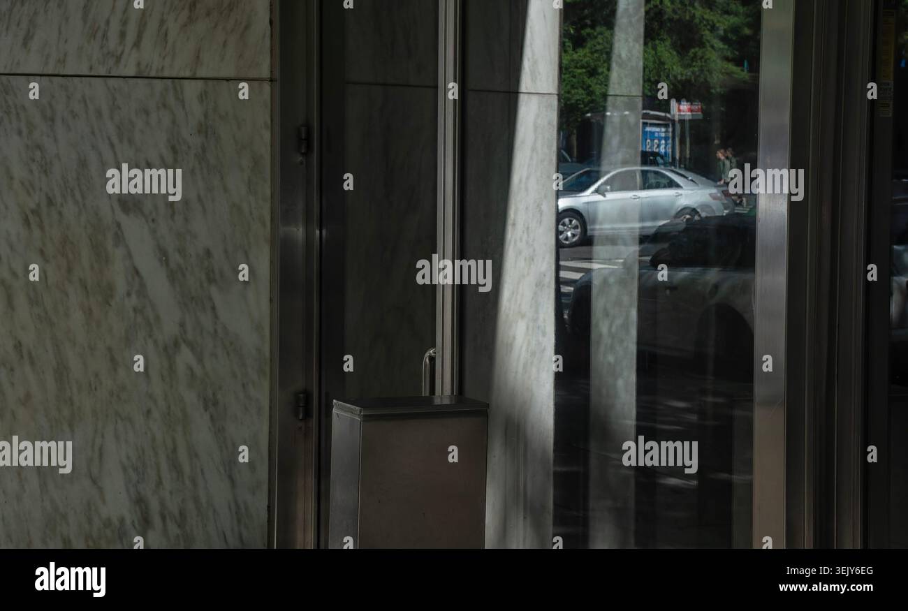 A parked car reflected in an office building window Stock Photo