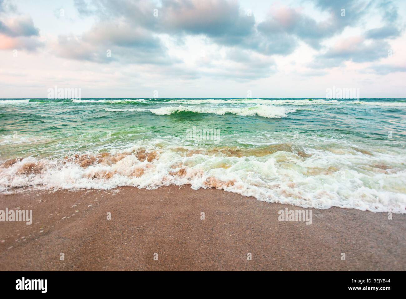 storm on the sandy beach in the afternoon. dramatic sea view with cloudy sky. salt water and crashing waves. view of bulgaria beach in summer. wind we Stock Photo