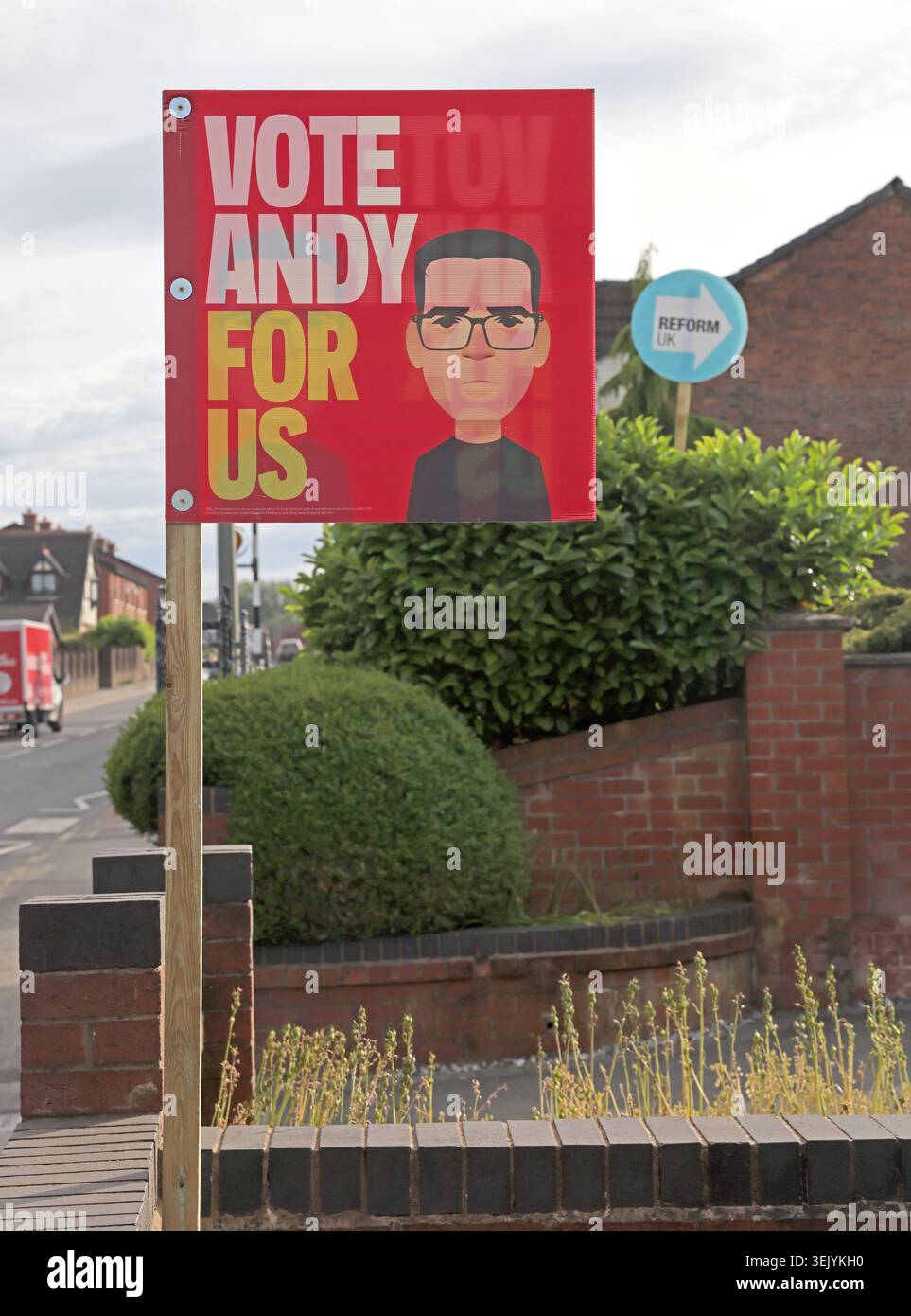Tall signs, Andy Burnham Labour poster and Reform UK signs face voters on Ashton-in-Makerfield street before the Makerfield by-election. Stock Photo