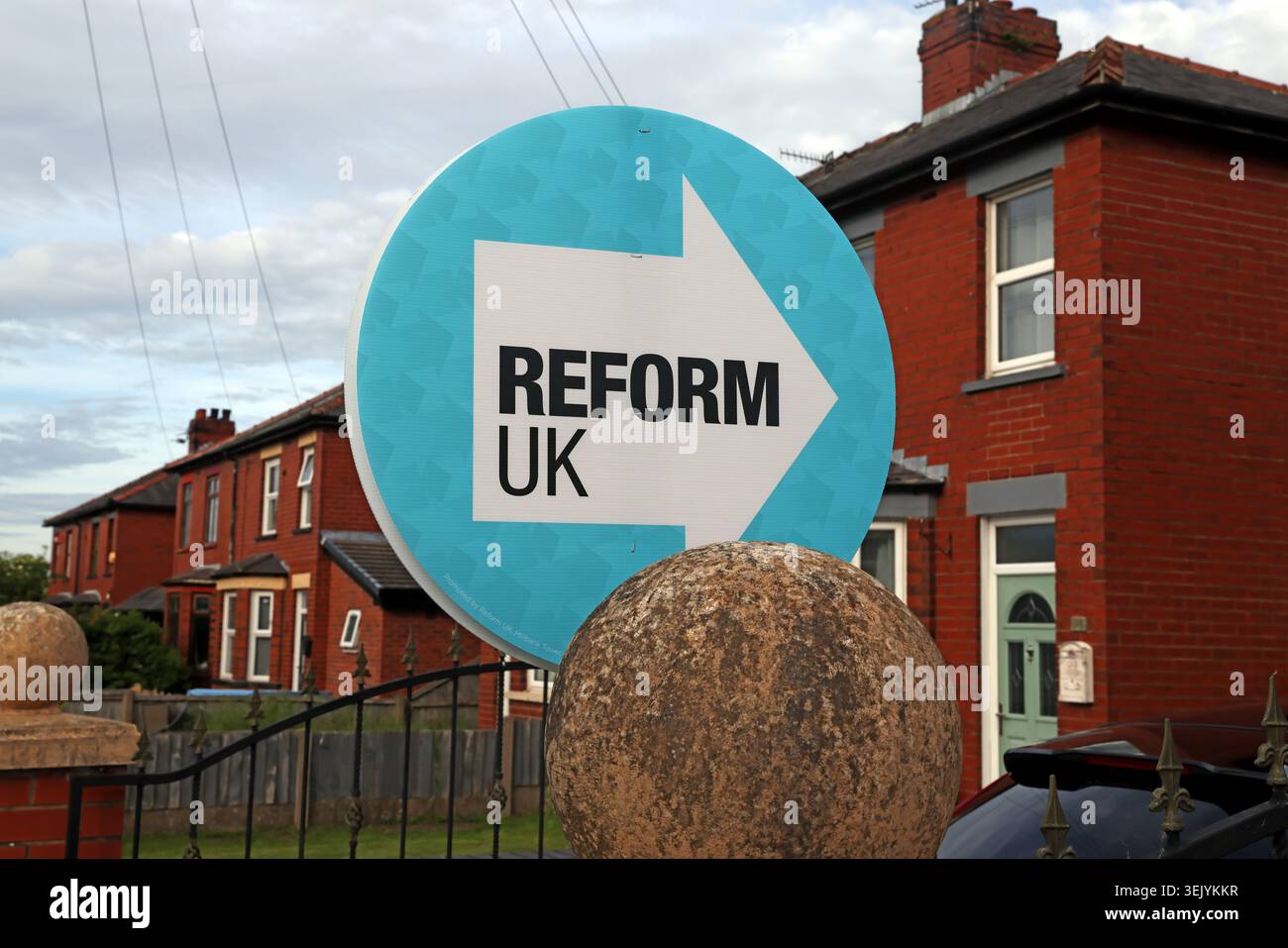 Reform UK roundel sign outside red-brick terraced houses in Makerfield during the 2026 Ashton-in-Makerfield by-election campaign. Stock Photo
