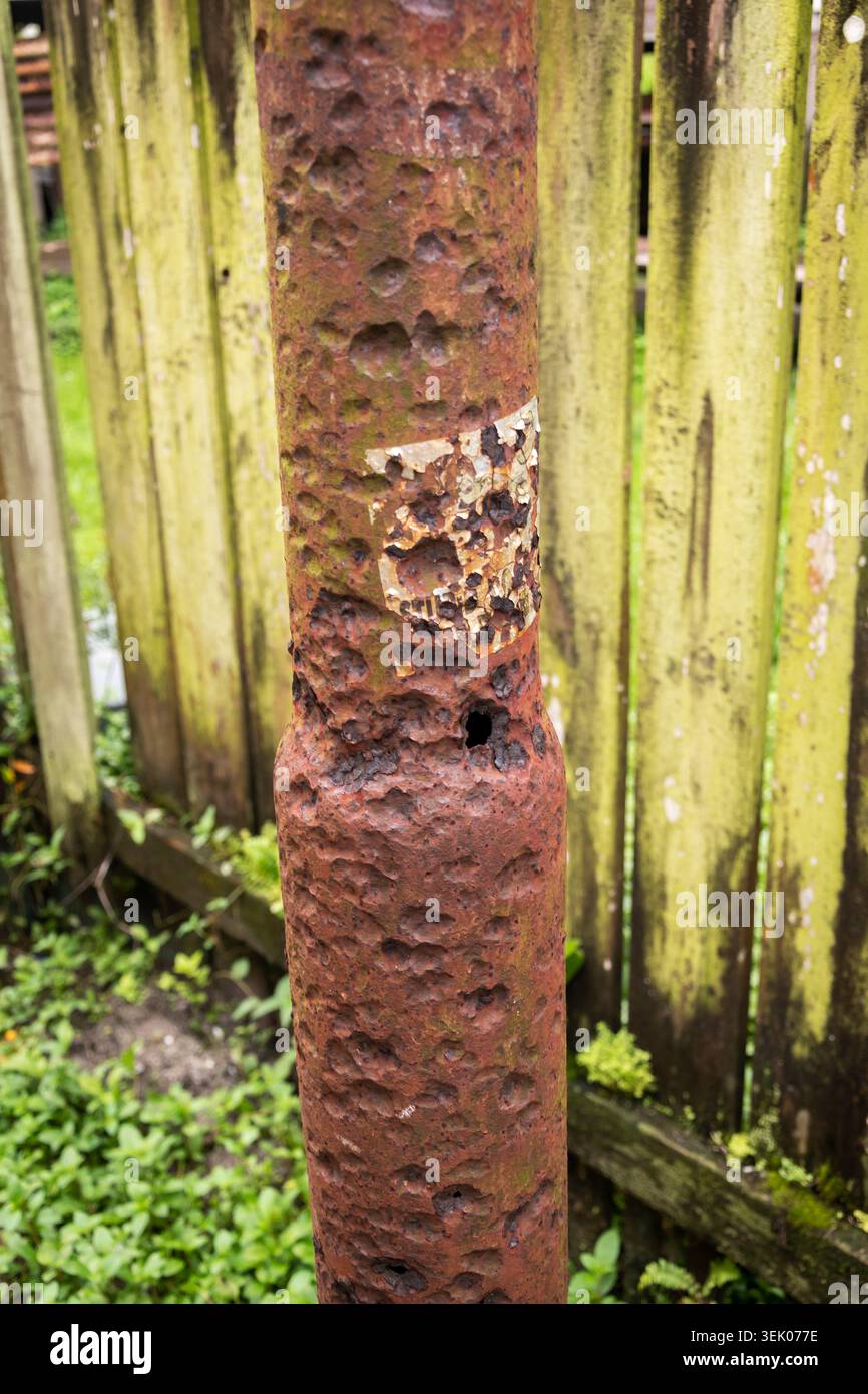 Severely corroded metal post with rust damage in tropical climate Stock Photo