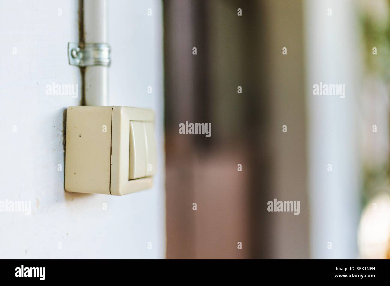 Vintage wall mounted light switch with exposed electrical conduit in rustic building interior Stock Photo
