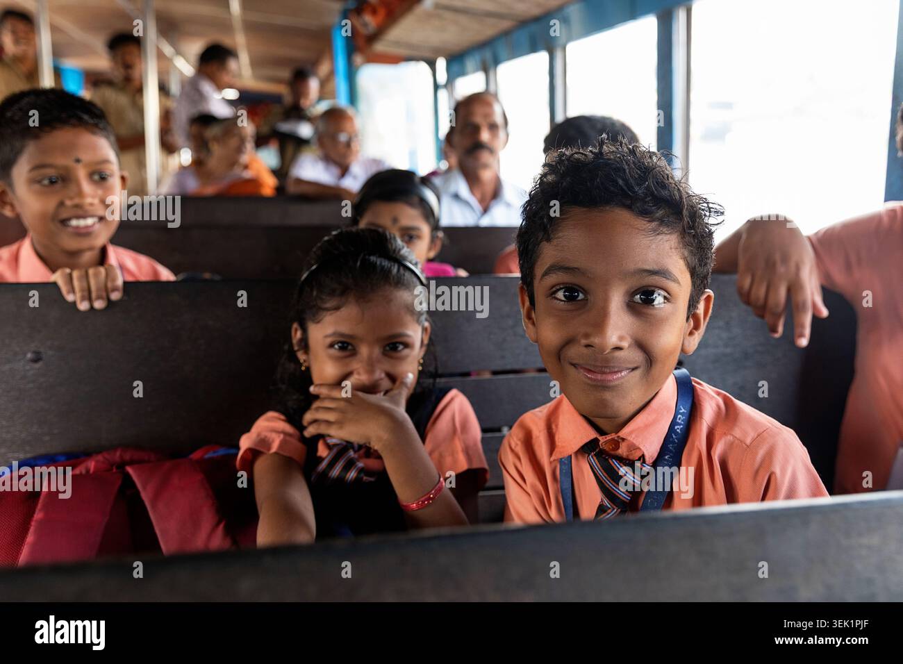 Children commuting to school sitting inside a local public ferry boat ...