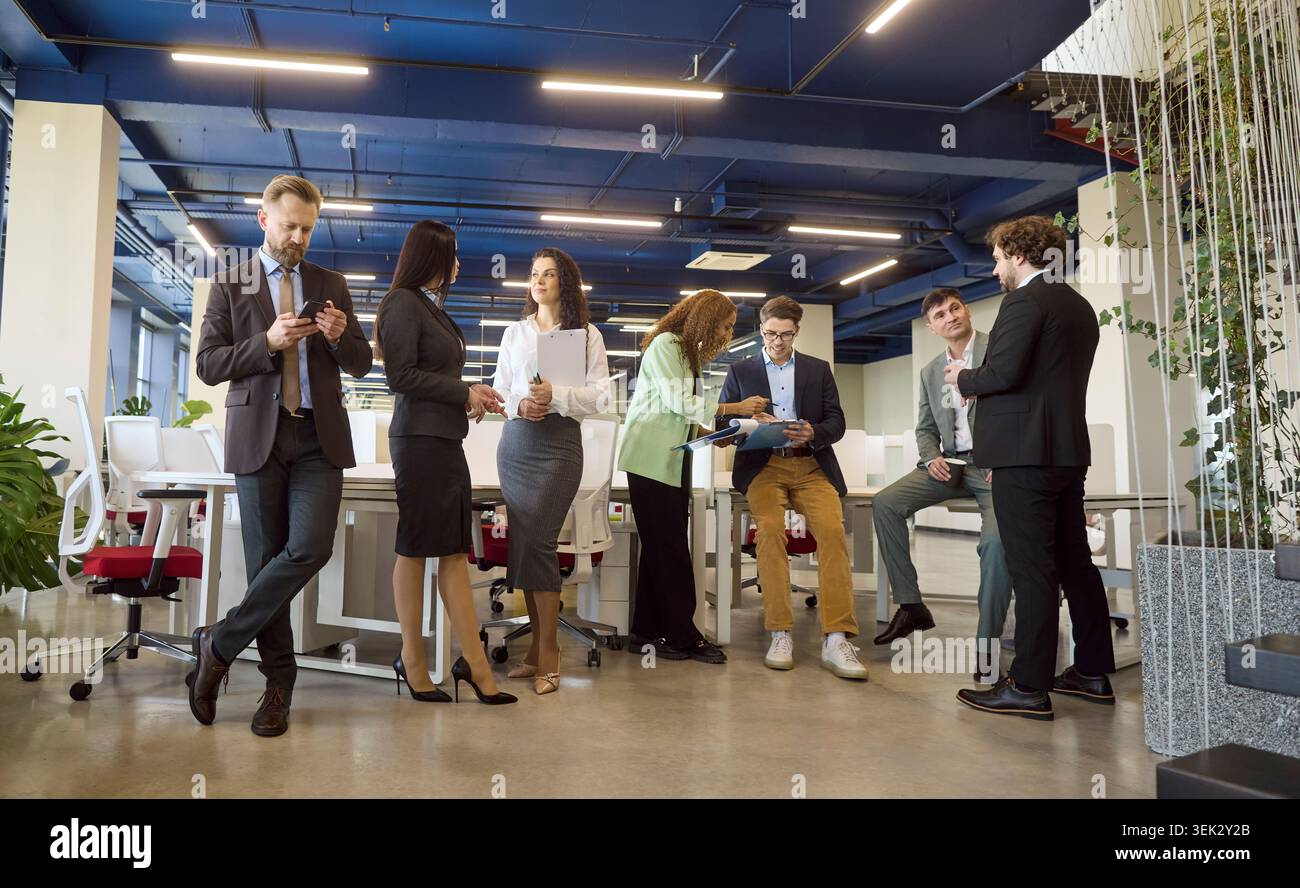 Diverse business team networking and collaborating in modern open plan office space Stock Photo