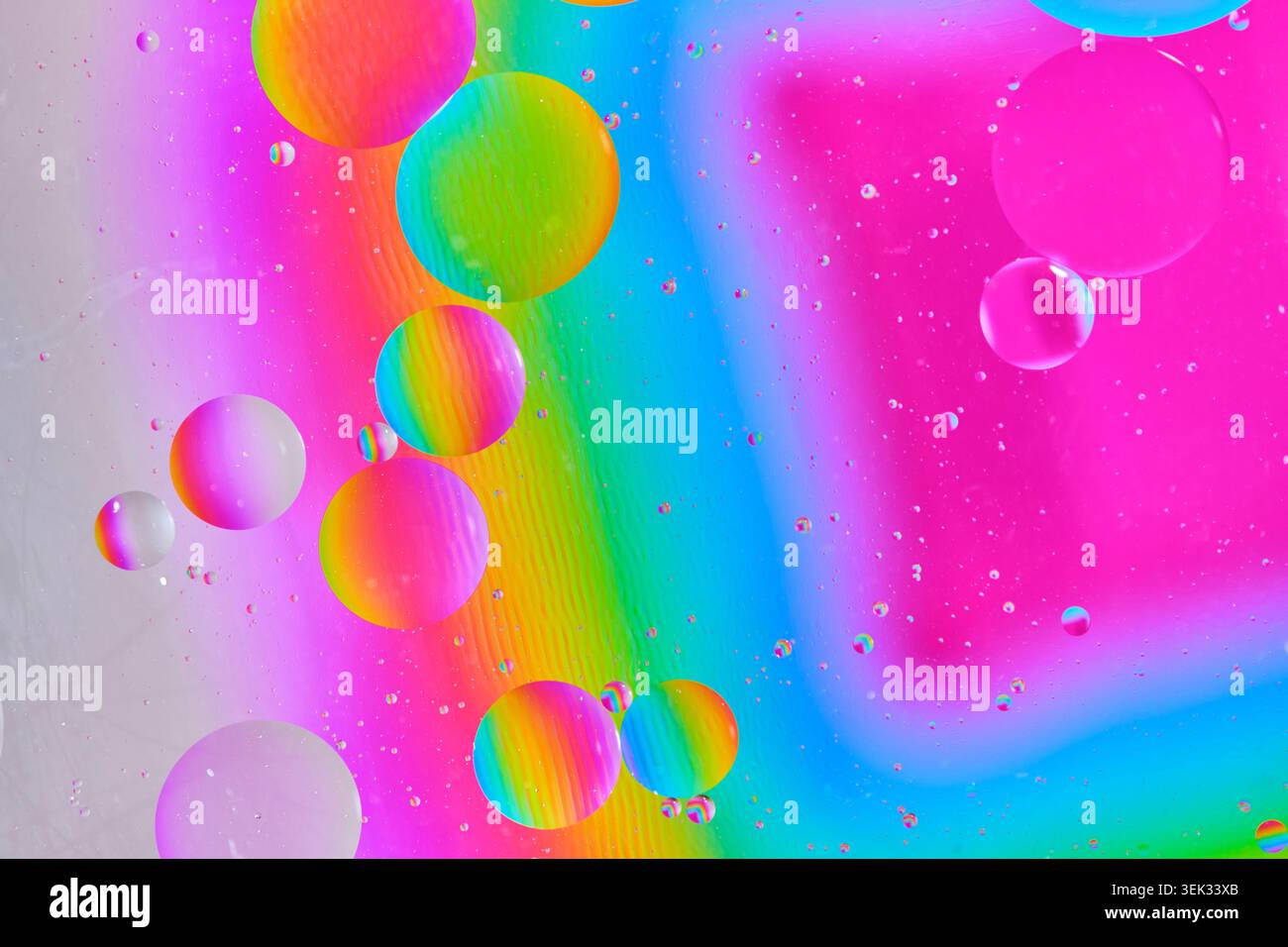 Bright multicolored macro texture with floating oil spheres over neon rainbow gradient backdrop Stock Photo