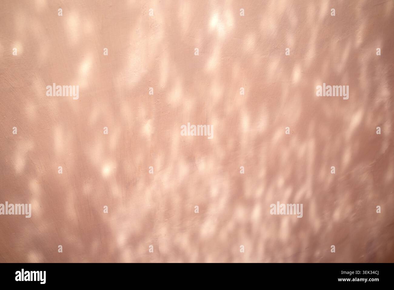 Soft pink wall with sunlight reflections and abstract textured light pattern Stock Photo