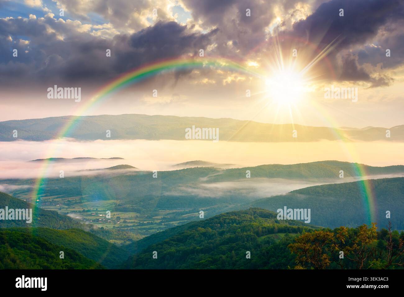 sunset over foggy carpathian countryside scenery in summer. view of mountainous landscape with rural fields on rolling hills. fog in the valley. cloud Stock Photo