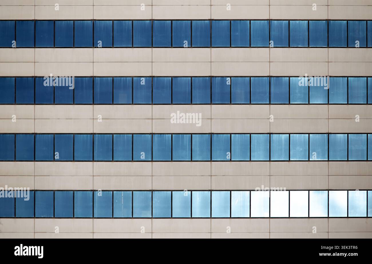 Modern office building facade with repetitive blue windows pattern Stock Photo