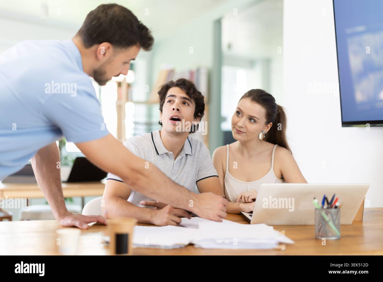 Colleagues work on paper drawing, making sketches while discussing construction plan in office Stock Photo