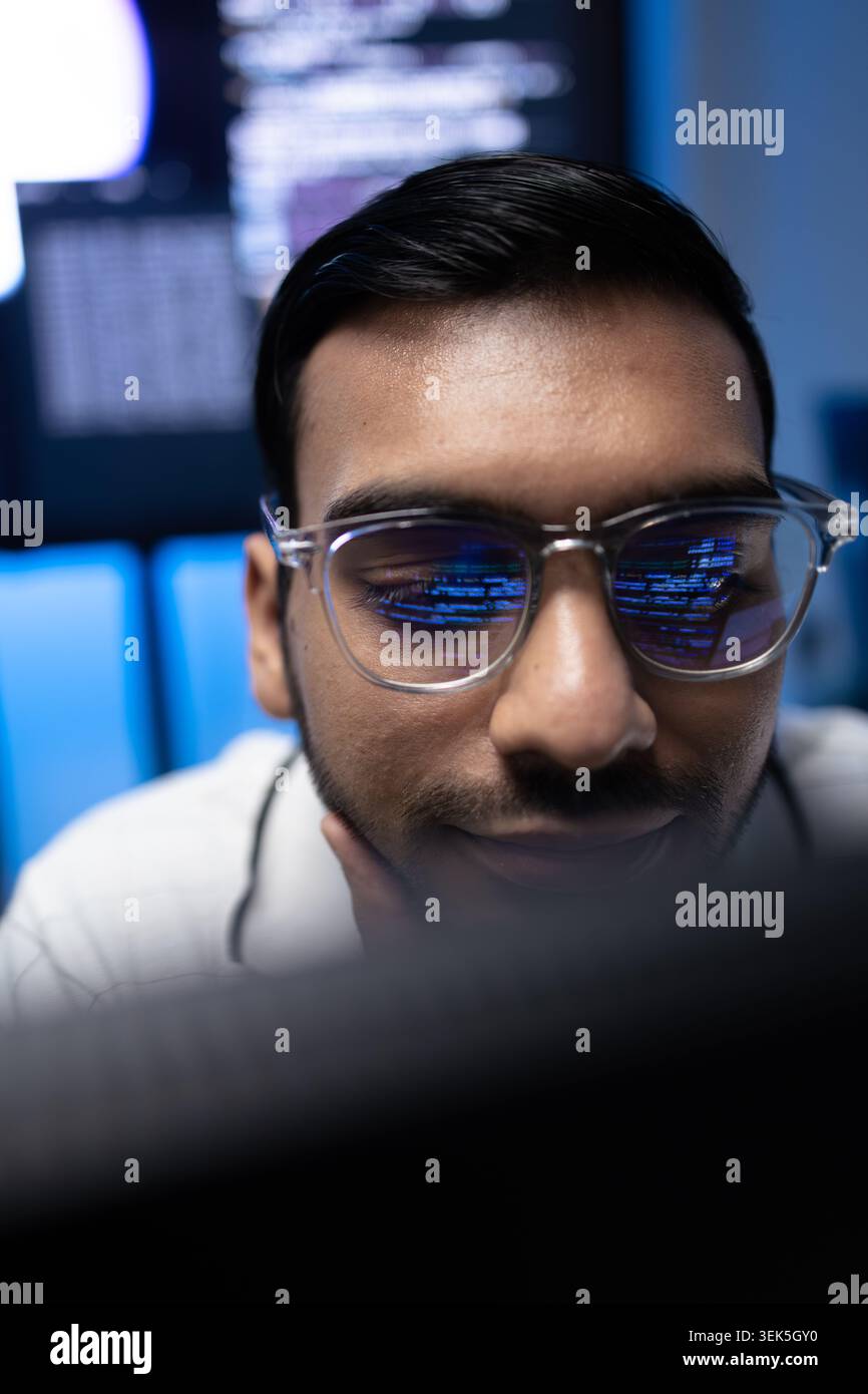 Vertical Portrait Of Indian Software Developer With Code Reflection On Glasses Stock Photo