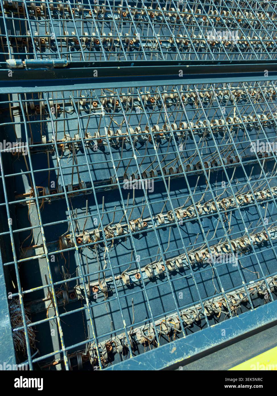 Workers are using a metal grid with wires and rods at a construction ...