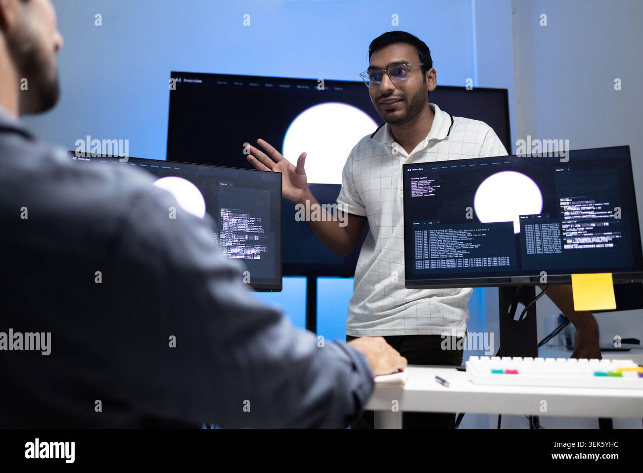 Indian Coding Instructor Teaching AI Programming Lesson To Student In Tech Office Stock Photo