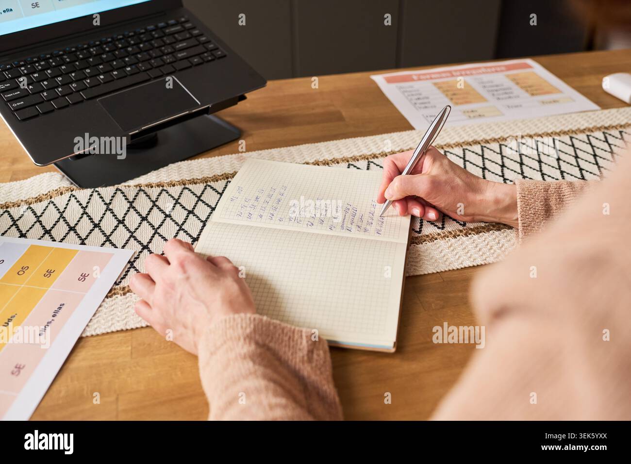 Middle Aged Woman Taking Notes during Online Skills Training Stock Photo