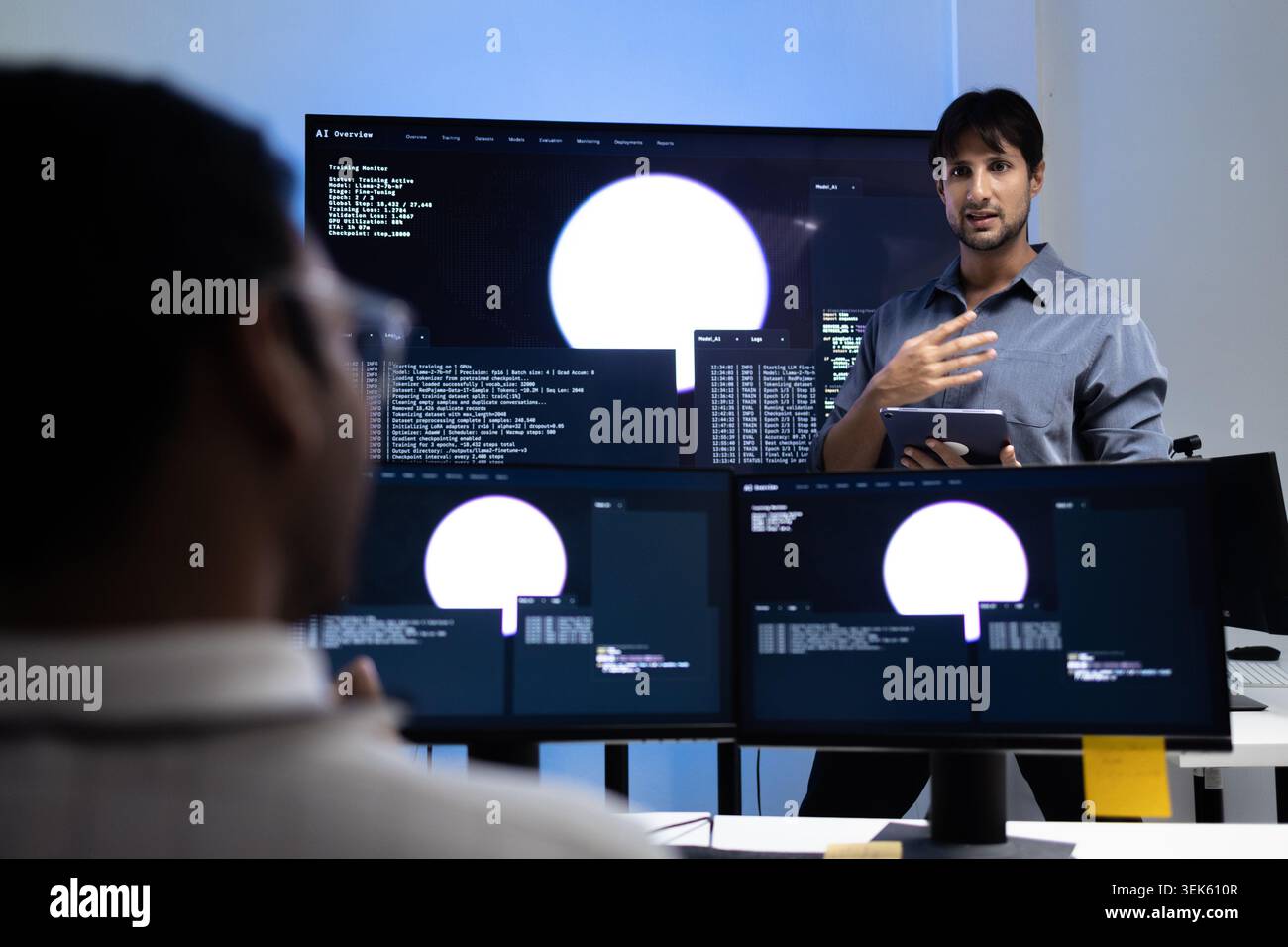 Young Programming Instructor Teaching AI Training Lesson In Tech Office Stock Photo